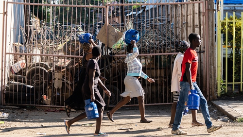 People carry supplies on the streets of Bulawayo, Zimbabwe