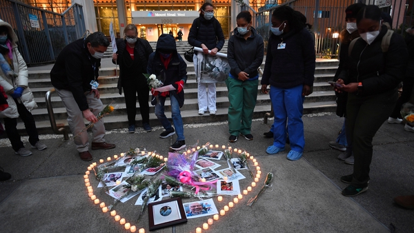 Nurses and healthcare workers in New York light candles for colleagues who died