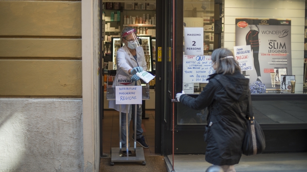 A pharmacist in Bologna, Italy, distributes face masks to the public