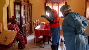 Members of the South Sudanese Ministry of Health Rapid Response Team prepare to take a sample from a woman at her home in Juba, South Sudan
