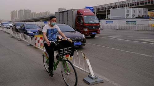 A Chinese cyclist wears a protective mask in Beijing on Friday