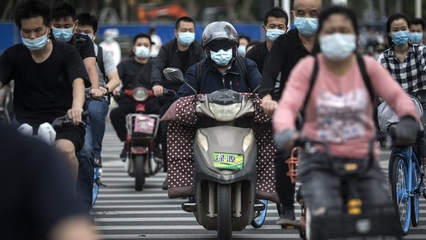 Residents wears face masks while riding their motorcycles yesterday in Wuhan