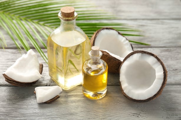 Bottles with fresh coconut oil on wooden table