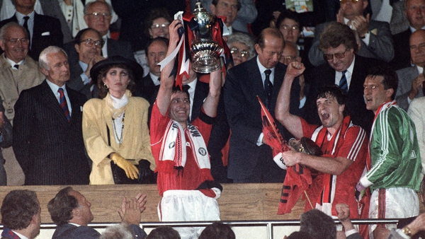 Manchester United captain Bryan Robson holds up the FA Cup in 1990
