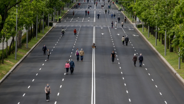 People walk on a deserted road in Madrid