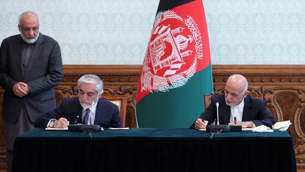Afghanistan's President Ashraf Ghani (R) and Abdullah Abdullah (L) signing an agreement during a meeting in Kabul