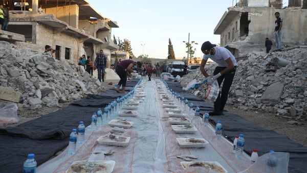 A volunteer prepares a makeshift table for a Ramadan meal amidst the ruins in Atareb town in the western countryside of Syria's Aleppo province. Photo: AAREF WATAD/AFP via Getty Images