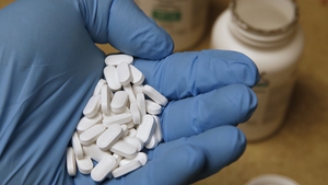 A pharmacy tech holds pills of hydroxychloroquine