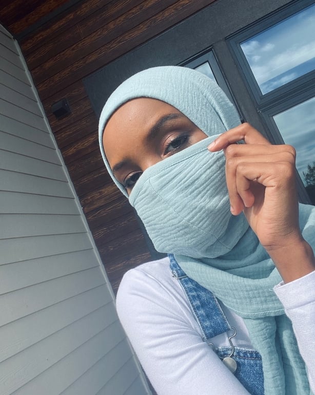 Halima Aden wearing a hijab and face mask