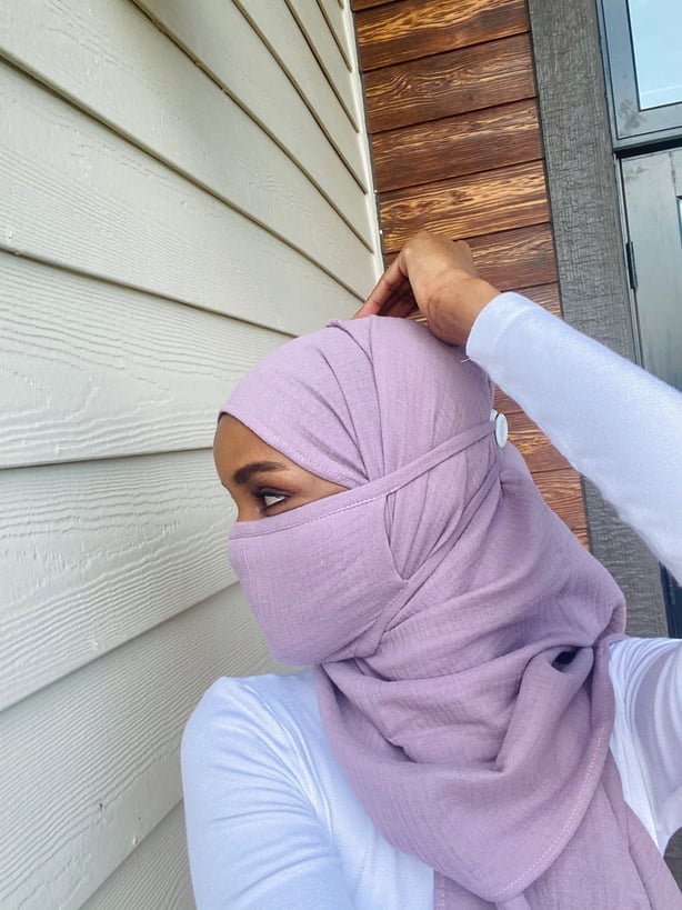 Halima Aden wearing a hijab and face mask