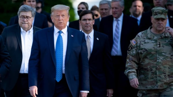 General Mark Milley (R) was wearing his battle uniform when he accompanied Donald Trump on the walk
