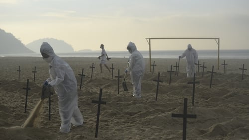 Protesters dig mock graves on Copacabana beach in Rio de Janeiro symbolizing deaths in Brazil due to the Covid-19