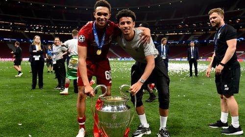 Trent Alexander-Arnold (L) and Curtis Jones pose with the Champions League trophy after Liverpool's win Madrid last year