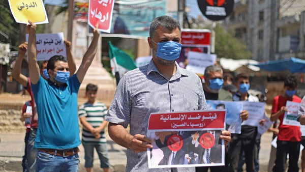 Syrian protesters in Idlib carry placards expressing their opposition to regime ally Russia's attempt to reduce cross-border aid
