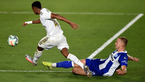 Rodrygo (L) of Real Madrid is tackled by Rodrigo Ely of Alaves