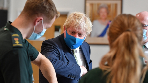 Prime Minister Boris Johnson wearing a face covering elbow bumps a paramedic as he visits the HQ of the London Ambulance Service