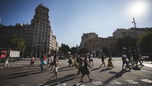 People cross the Gran Via de Les Corts Catalanes in Barcelona