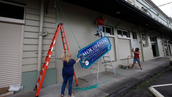 Citizens in Hilo, Hawaii remove signage in preparation for Hurricane Douglas
