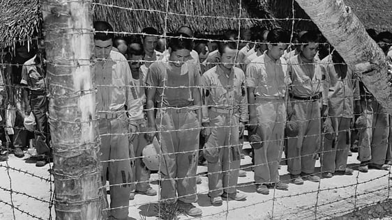 Japanese prisoners of war in an internment camp in Guam bow their heads after hearing Emperor Hirohito make the announcement of Japan's unconditional surrender. August 15, 1945. (Photo by © CORBIS/Corbis via Getty Images)