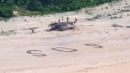 Australian and US warplanes spotted a giant "SOS" the men had scrawled on the beach (Photo courtesy of Australian Defence Force) Australian and US warplanes spotted a giant "SOS" the men had scrawled on the beach (Photo courtesy of Australian Defence Force)