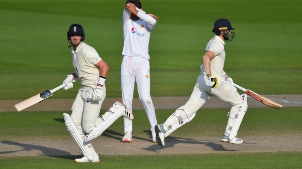 Stuart Broad and Chris Woakes run as Shaheen Afridi of Pakistan looks on dejected