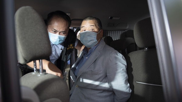 Jimmy Lai is placed in a vehicle by police after he was arrested at his home in Hong Kong