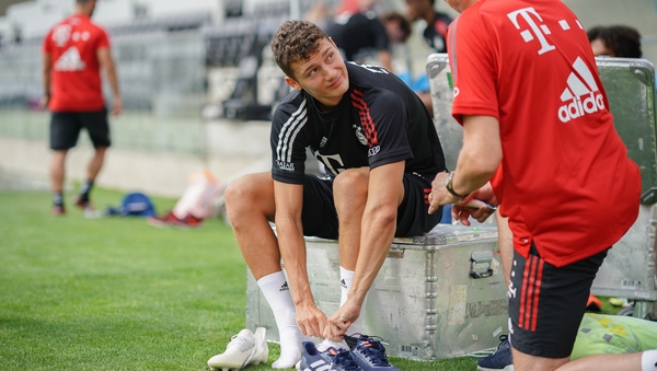 Benjamin Pavard speaks with a Bayern staff member during a training session at Cidade do Futebol