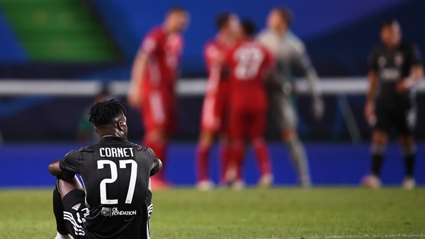 Bayern Munich players celebrate at the final whistle as Lyon's Maxwel Cornet sits dejected