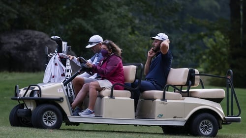 Dustin Johnson is driven off the golf course during a weather delay
