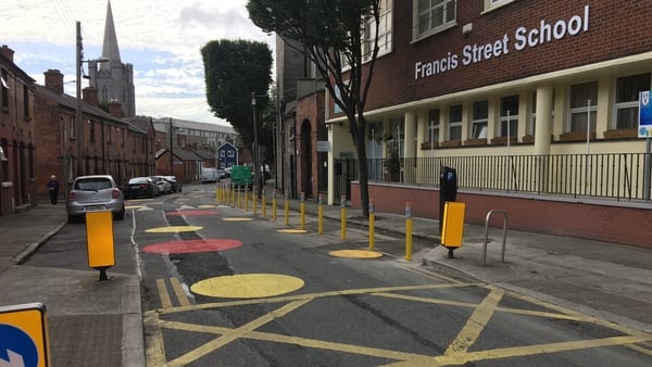 The area is demarcated by colour circles and pencil-shaped bollards to prevent illegal parking in the vicinity of a school