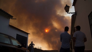 People look at smoke billowing from the fire in El Buitron