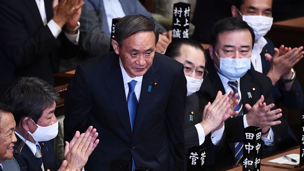 Yoshihide Suga takes the applause in parliament after being voted in as prime minister