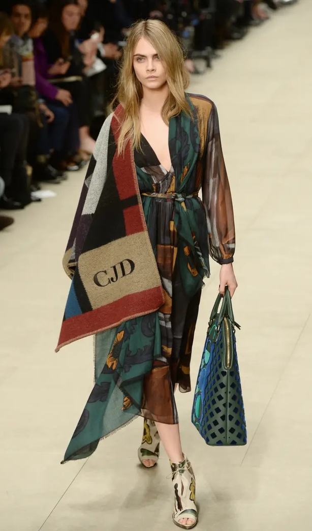 Delevingne models a Burberry scarf/cape hybrid in 2014 (Anthony Devlin/PA)