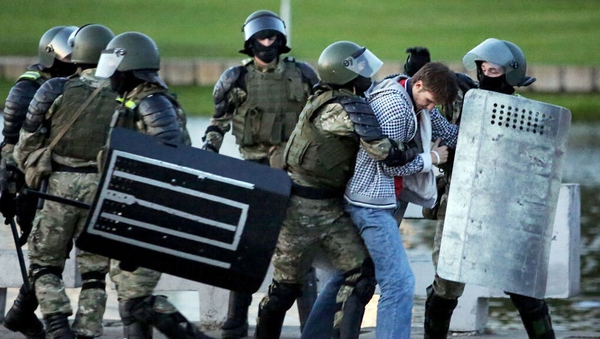 Law enforcement officers detain a man during an opposition rally in Minsk
