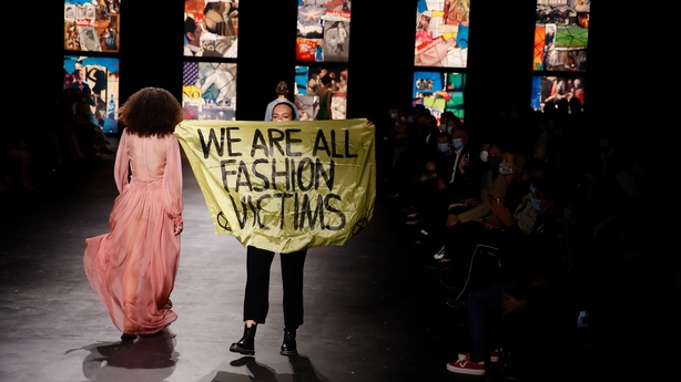 A woman with a sign jumped onto the catwalk just before the show's finale (Francois Mori/AP)