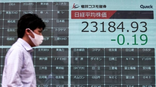 A man walks past a blank electronic board usually displaying Tokyo Stock Exchange share prices after trading was halted due to a glitch today