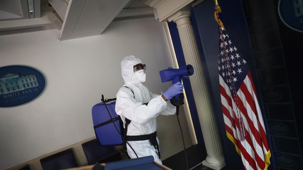 A member of the White House cleaning staff sanitizes the James S Brady Press Briefing Room