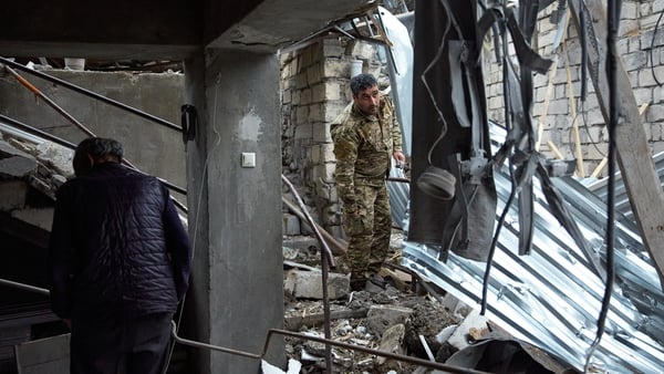 An Armenian soldier is seen in the wreckage of a home damaged by Azeri artillery in Stepanakert