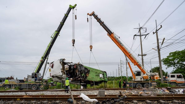 The damaged freight train is removed from the crash site