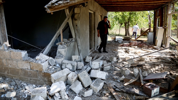A man looks through the remains of a home that was damaged by Armenian artillery in Tartar, Azerbaijan