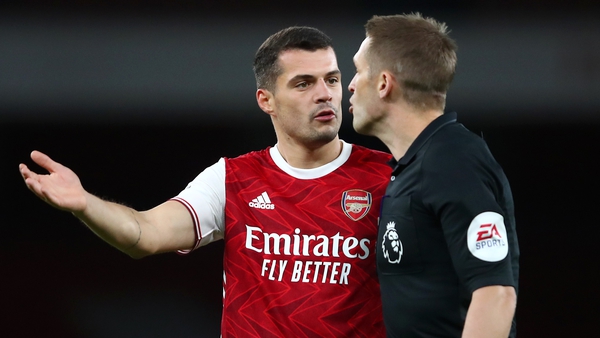 Granit Xhaka of Arsenal confronts referee Craig Pawson