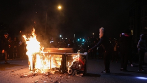 Demonstrators stand near a burning barricade in Philadelphia during second night of unrest