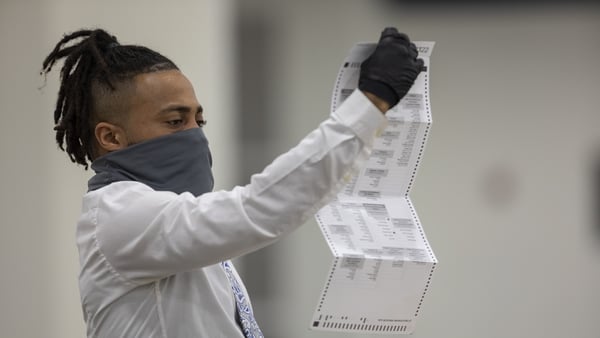 A worker with the Detroit Department of Elections inspects an absentee ballot