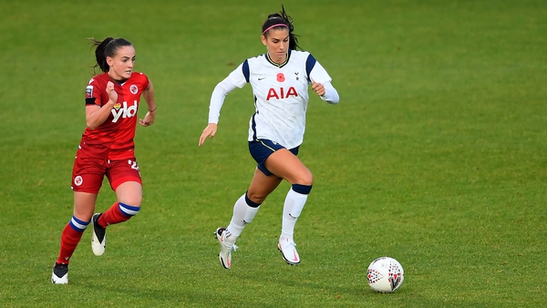 Alex Morgan of Tottenham Hotspur (R) runs with the ball under pressure from Lily Woodham of Reading
