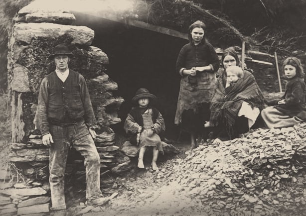 A family outside the ruins of their house in 1888