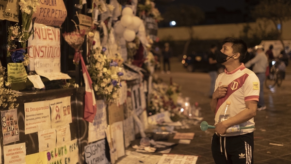 A man stands next to a memorial for the murdered during the massive protests next to National Congress in Lima, Peru