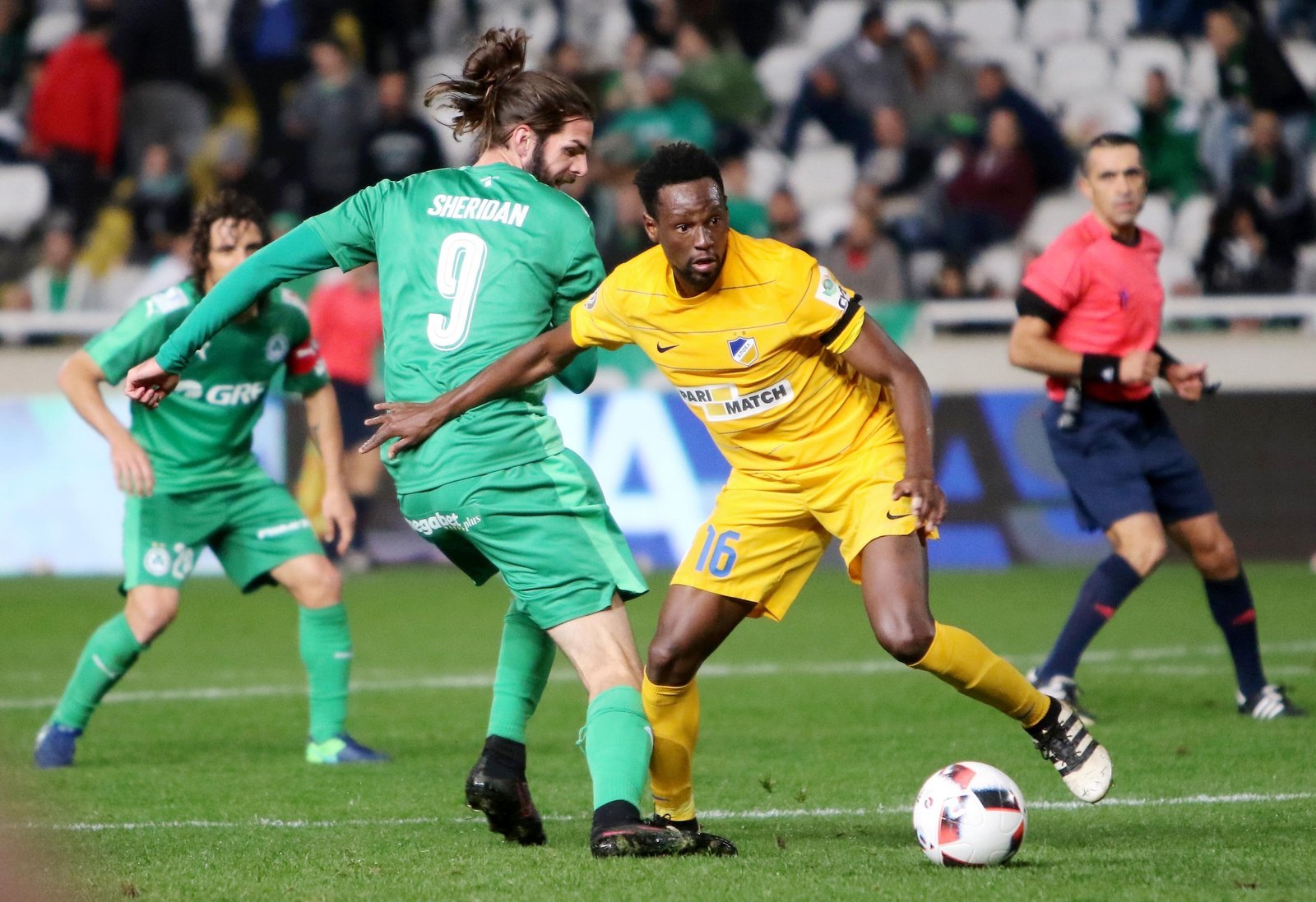 Image - APOEL FC's Vinicius Oliveira Franco (R) fights for the ball against Sheridan's Omonia in the derby
