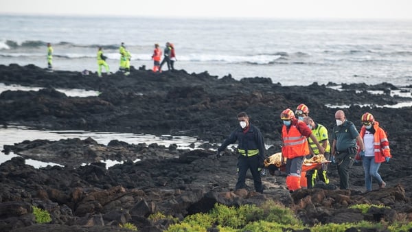Rescue workers carry a body off Orzola beach in Lanzarote