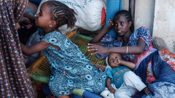 An Ethiopian family rests in a makeshift shelter in Sudan after fleeing conflict in Tigray