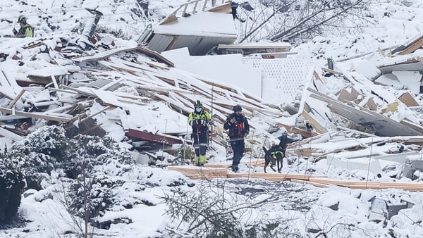 Rescue workers with a dog searching the landslide area in Ask, Norway today